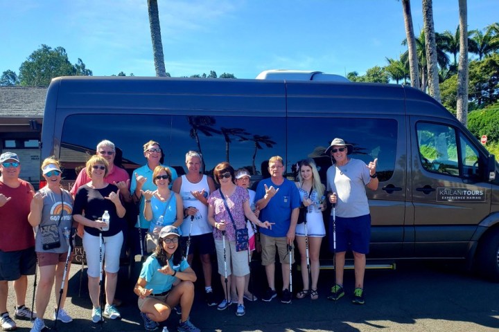 a group of people standing in front of a car posing for the camera