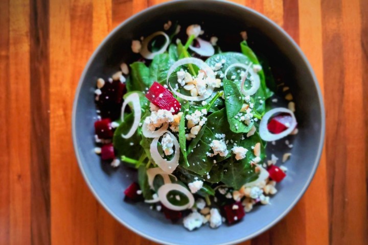 a bowl of food sitting on top of a wooden table