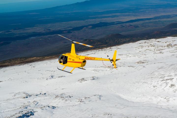 a small plane sitting on top of a snow covered mountain