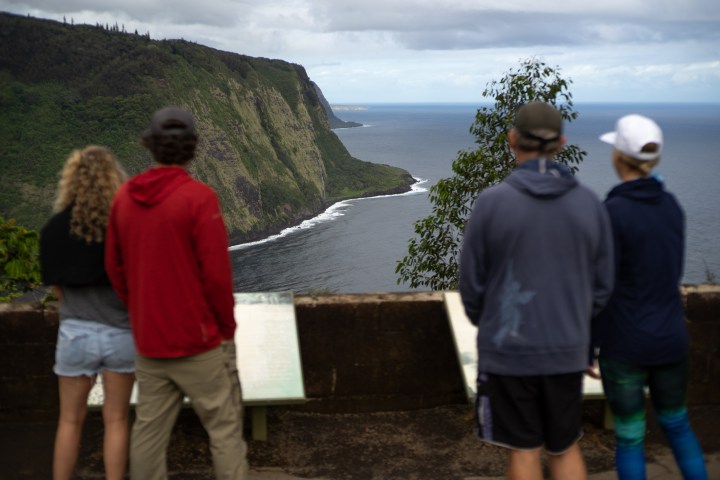 a group of people standing next to a body of water