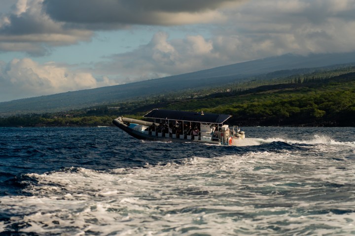 a boat on a body of water with a mountain in the background